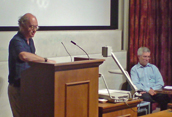 Two men standing at the front of a lecture theatre