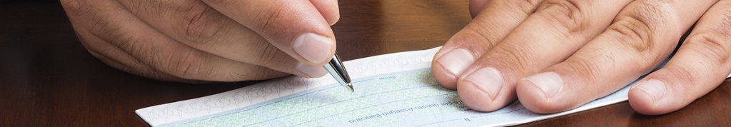 Close up of hands writing a cheque