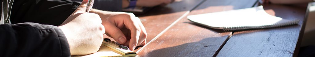 Person making notes on a pad of paper