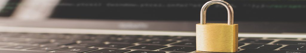 Brass padlock sitting on top of a laptop keyboard