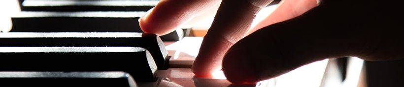 Fingers touching keys on a piano keyboard