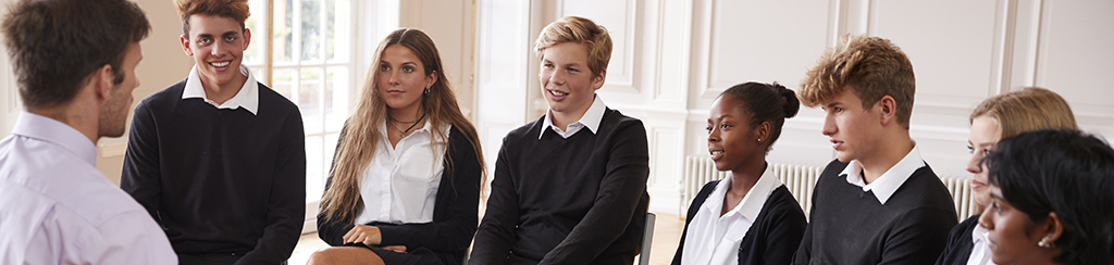 Group Of Teenage Students Having Discussion With Tutor