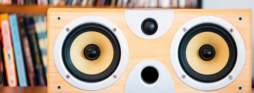 Sound speaker with a shelf of books in the background