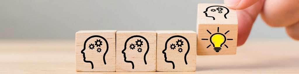 Four wooden blocks with thinking heads drawn on them